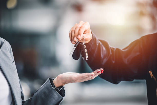 Car keys being handed over between seller and buyer